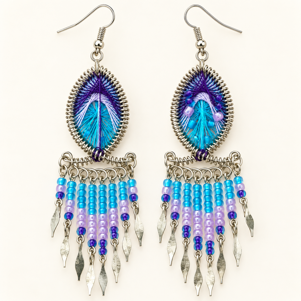 Turquoise-blue and purple threadwork earrings with beaded fringe and silver-tone leaf-shaped accents